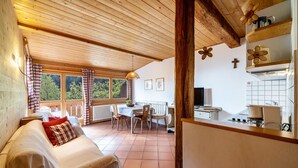 Una habitación acogedora con cama, una mesa de comedor y una zona de cocina.