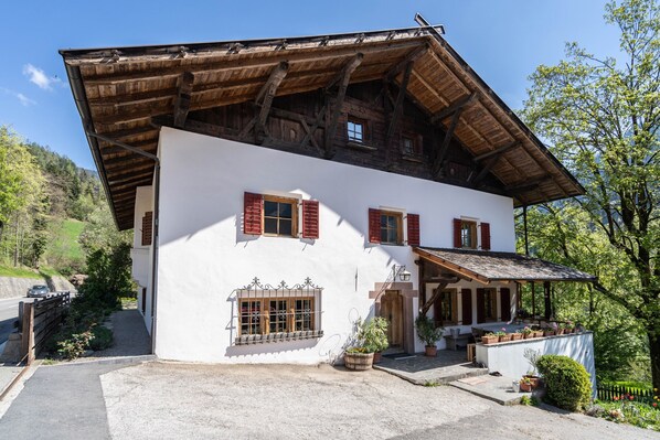 A traditional chalet with a sloped roof, wooden beams, and a stone foundation.
