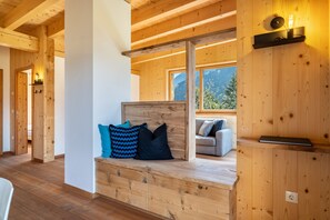 Ein Holzinterieur mit einer Bank, einem Sofa und einem an der Wand befestigten Regal.