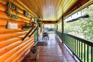 A wooden cabin with a porch, a view of the river, and a sign that reads 'New River.'