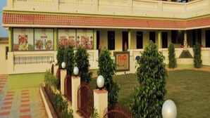 A two-story building with a red-tiled roof, a covered walkway, and a sign reading "R&D". - Saanvi Resort Bhavnagar (Bhavnagar)