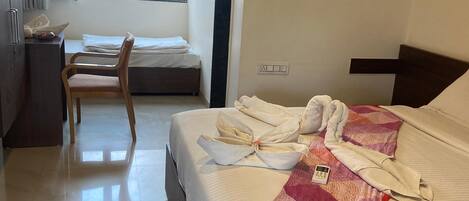 Una habitación de hotel con una cama, un escritorio, una silla y una ventana.