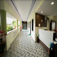 A hotel reception area with a patterned floor, a reception desk, and a sign indicating the 'SUMMIT' room.