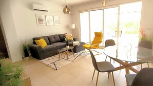Un salon moderne comprenant un canapé, une table basse et une table à manger avec des chaises.