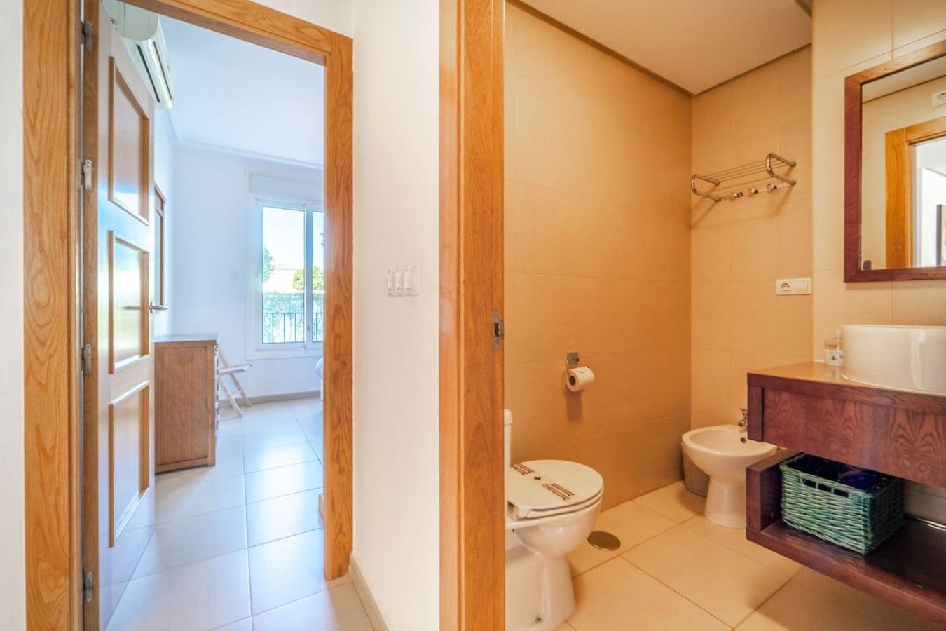 Ein Badezimmer mit Toilette, Bidet und Waschtisch mit Spiegel.