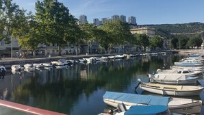 A marina with boats docked, a waterfront promenade, and buildings in the background. - La Guardia apartments (Rijeka)