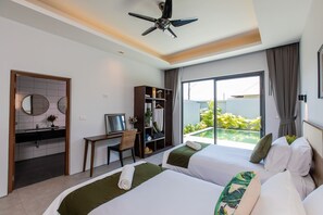 A hotel room with two beds, a desk, a chair, a wardrobe, and a balcony with a view of greenery. - Blu Boat Luxury Pool Villas (Choeng Thale)