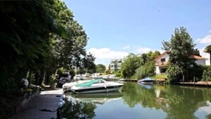 A calm waterway with boats docked, surrounded by greenery and buildings. - 3-room apartment near the sea - luxury residence (Mandelieu-la-Napoule)