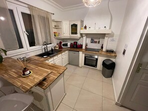 Compact kitchen with sink, microwave, coffee maker, and small oven.