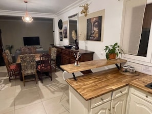 Enjoy meals in the kitchen with a dining area, TV, and potted plant.