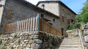 A stone building with a wooden fence and stone steps leading to a door. - Gîte in an Ardéchois farmhouse in the heart of nature (Fabras)