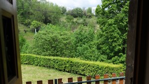 A stone pathway leading to a wooden fence overlooking a lush green garden. - Gîte in an Ardéchois farmhouse in the heart of nature (Fabras)
