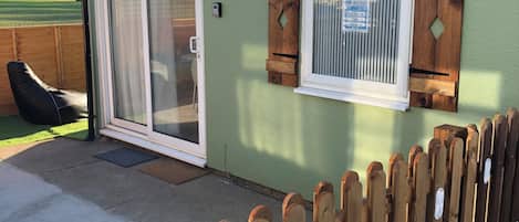Ein Gebäude mit einem 'Be our guest' Schild, einem Holzzaun und einem Fenster mit Jalousien.