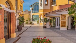A courtyard with a bar, potted plants, and a building with a sign indicating it is a typical Spanish tapas bar. - Villa in La Torre Golf Resort. pet friendly (Torre-Pacheco)