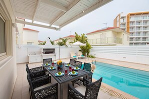 A covered outdoor dining area with a pool in the background. - Pernera holiday villa - rentprivatevillas 588 (Pernera)
