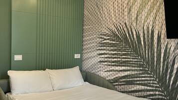 Ein modernes Schlafzimmer mit Bett, grüner Wand, strukturiertem Wandpapier und Deckenleuchten.