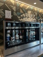 A wine dispensing machine with multiple wine bottles and glasses.
