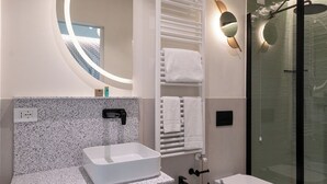 A modern bathroom with a freestanding sink, a bidet, a toilet, a glass-enclosed shower, and a wall-mounted towel rack. - Boutique Hotel Martini 17 (Milan)