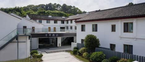 A courtyard with a building entrance, a staircase, and a small garden area.