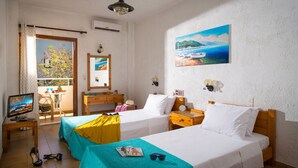 A hotel room with two beds, a TV, a desk, and a balcony with a view of the sea. - Floral Hotel (Hersonissos)