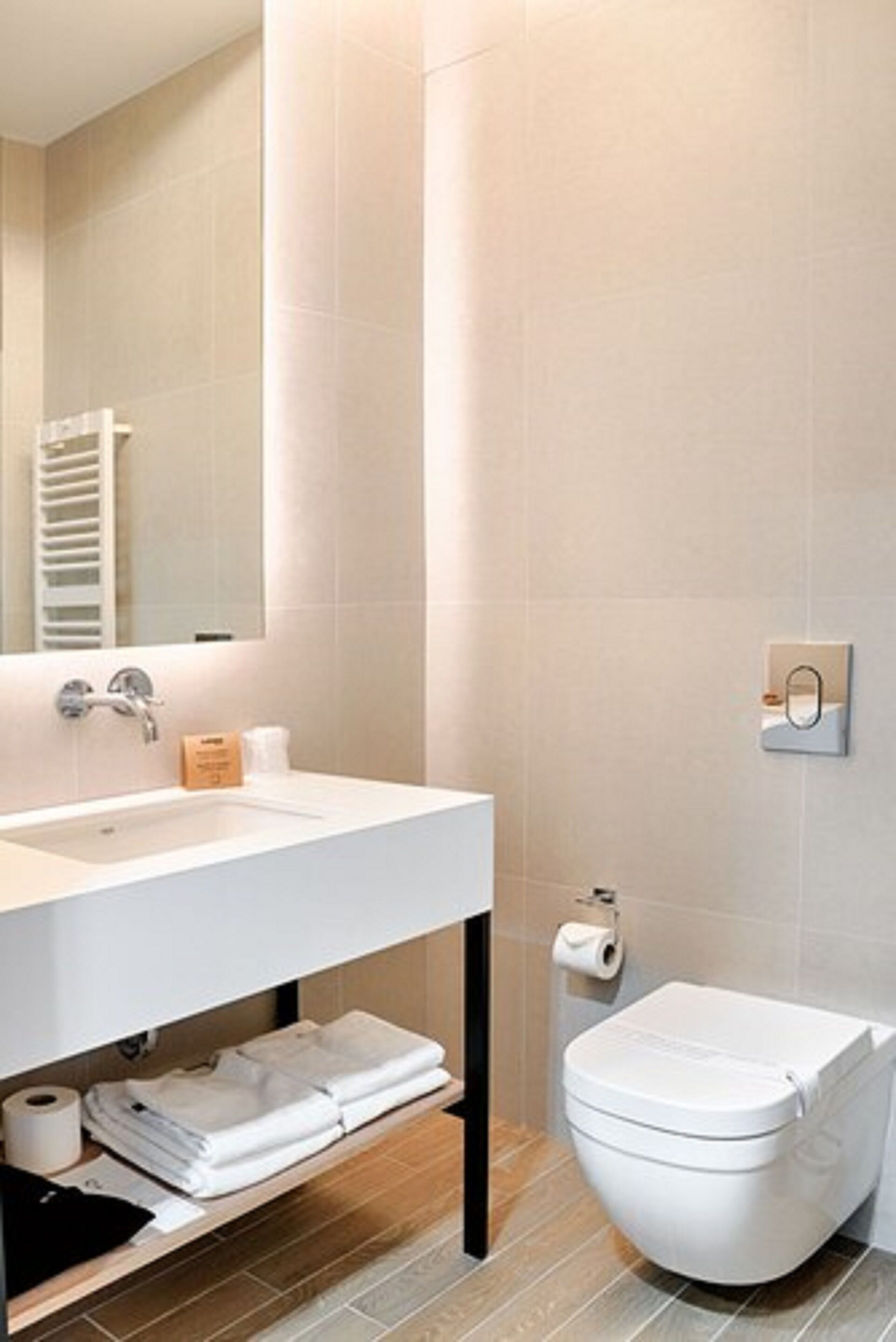 Ein modernes Badezimmer mit Waschbecken, Spiegel und Toilette in Weiß.
