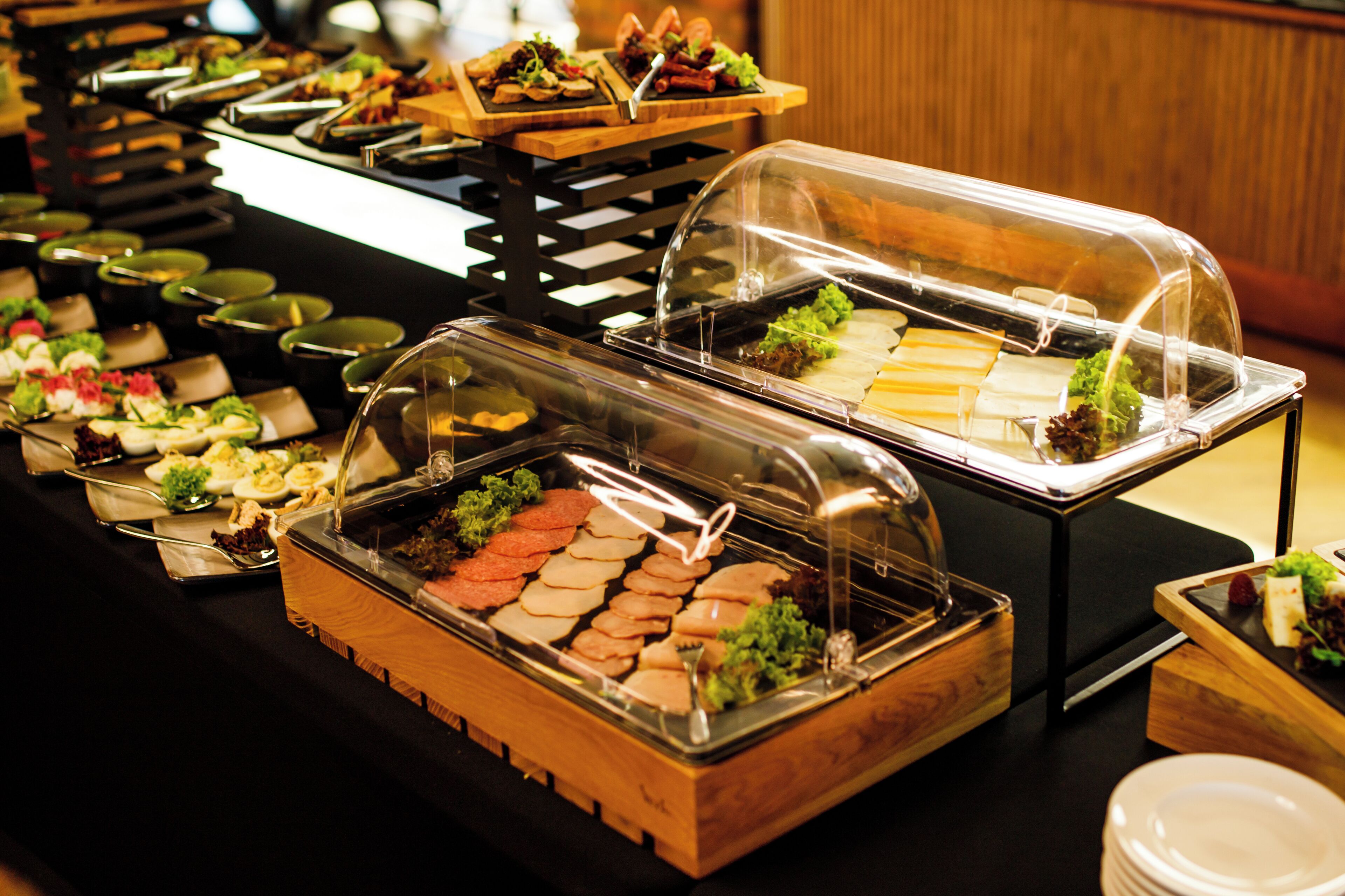 A buffet with various food items under glass covers.