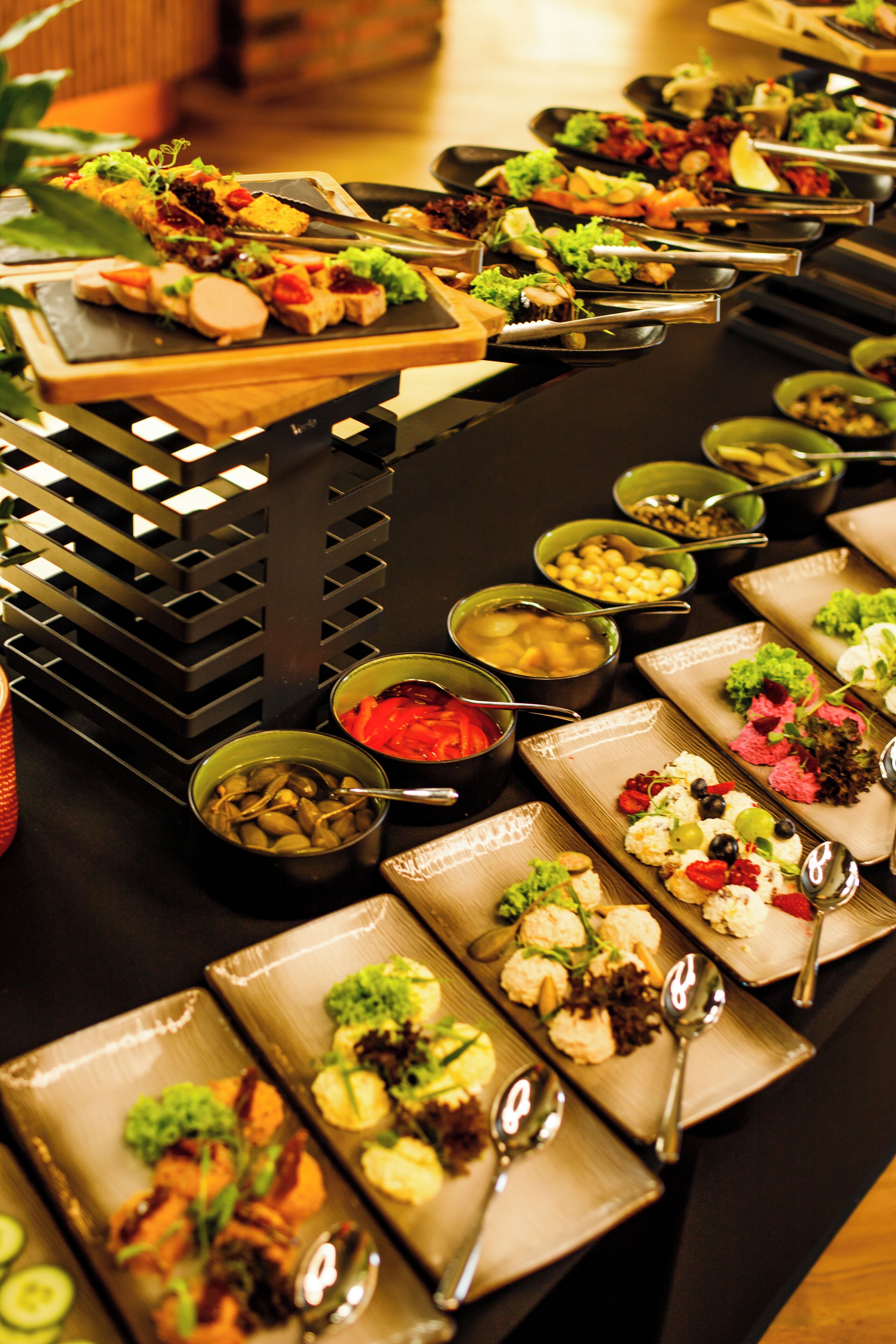A buffet table with various food items and serving utensils.