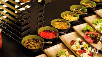 A buffet table with various food items and serving utensils.