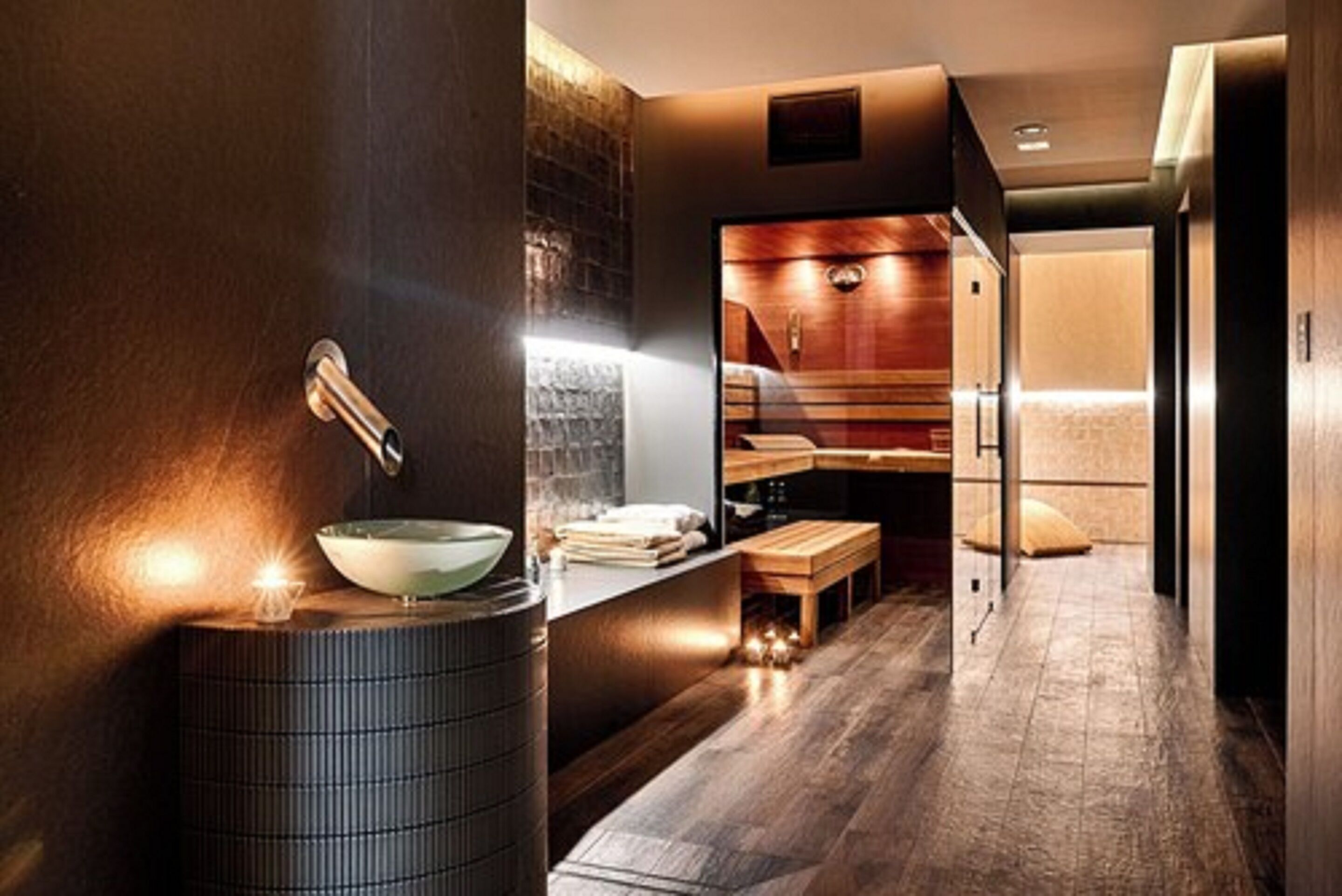 Une salle de bain moderne avec un grand lavabo, un miroir et un banc en bois.