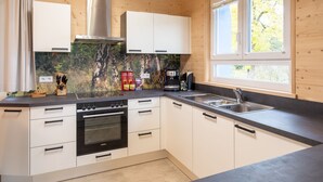 Eine moderne Küche mit weißen Schränken, einem schwarzen Backofen und einer Spüle aus Edelstahl.
