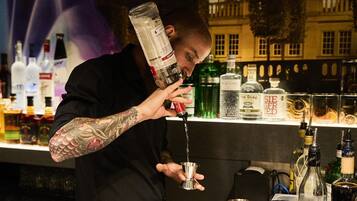 A bartender pouring a drink into a glass.