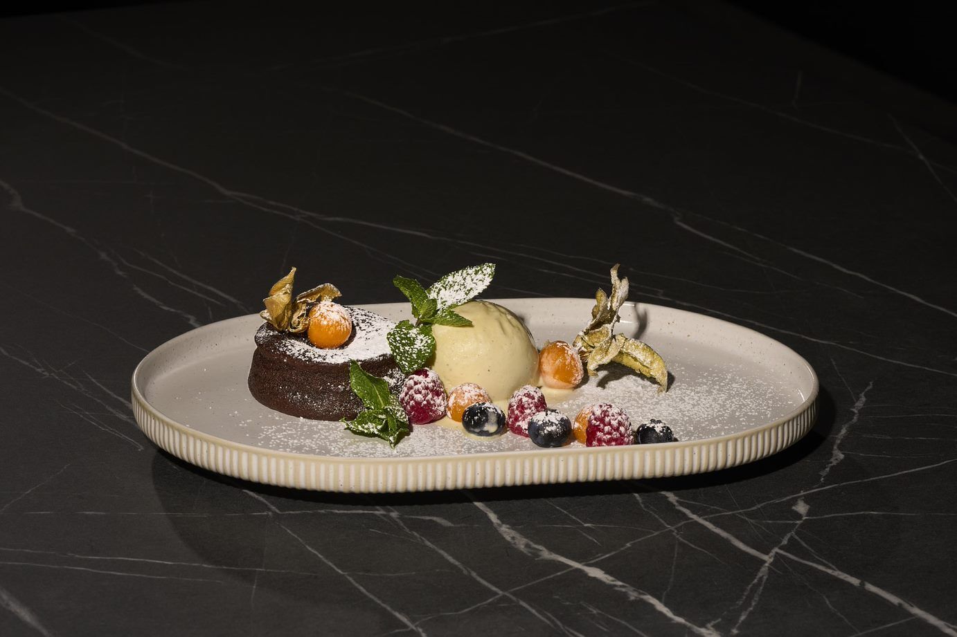 Ein Dessert auf einem weißen Teller vor einem Marmorfond.