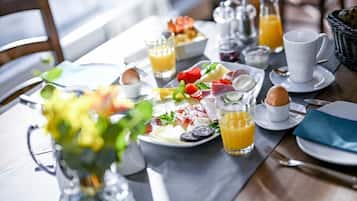 A breakfast setting with a variety of foods, drinks, and tableware.