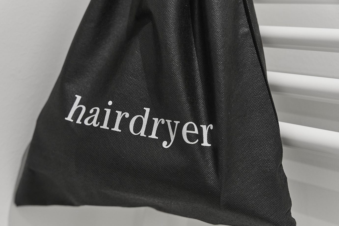 Una bolsa negra con la palabra "hairdryer" escrita en ella.