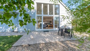 A modern house with large windows, a patio with outdoor furniture, and a well-maintained lawn. - Seashells - Three Bedroom House, Sleeps 6 (Woolacombe)