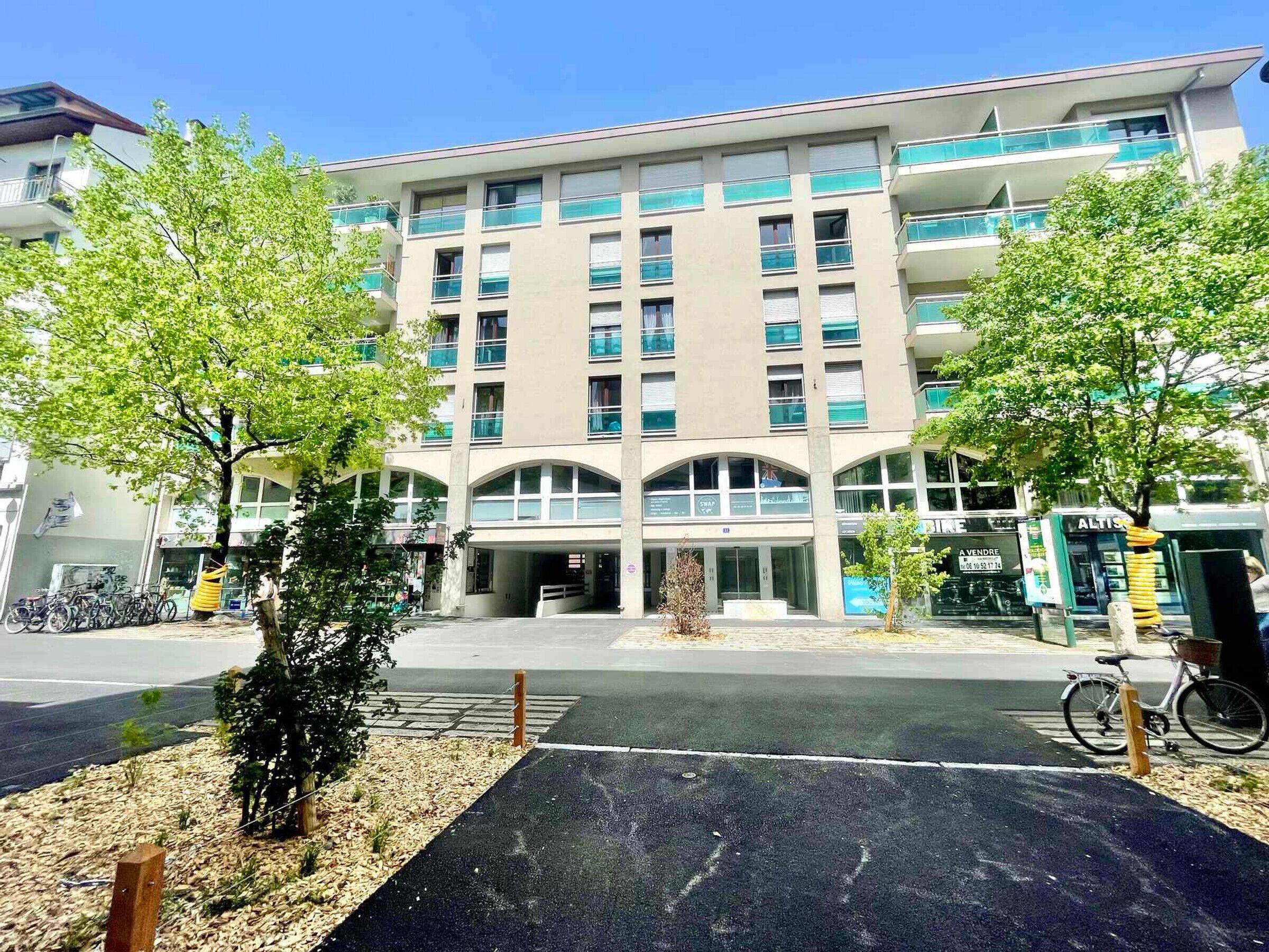 Un bâtiment moderne doté d’une entrée centrale, de plusieurs étages et d’un espace de stationnement pour vélos.