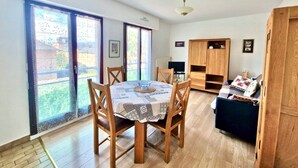 A dining area with a table set for four, wooden chairs, and a ceiling fan. - Cozy Apartment Downtown Annecy, Parking, Wi-Fi Included (Annecy)