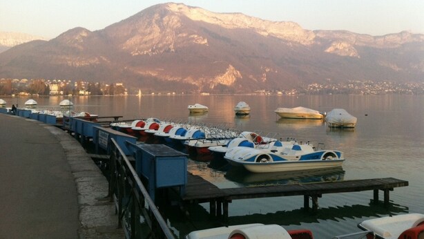 A lakeside dock with several boats and a mountain in the background. - Cozy Apartment Downtown Annecy, Parking, Wi-Fi Included (Annecy)