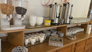 A coffee station with various coffee makers, cups, and a 'TEA' sign. - Thüringer Hof (Ziegenrueck)