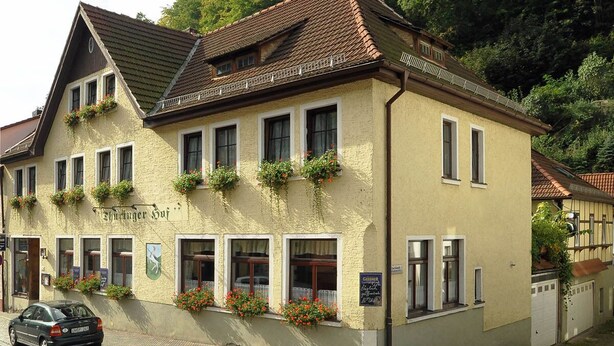 A traditional building with a sign reading "Tischlinder Hof" and flower boxes on the windows. - Thüringer Hof (Ziegenrueck)