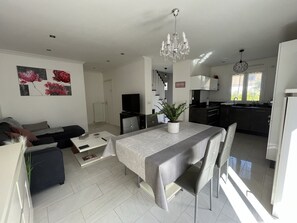 Una sala moderna con comedor, cocina y escalera.