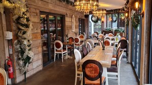 Un restaurante con paredes de madera, sillas blancas y una mesa larga.