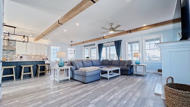 A spacious living area with a sofa set, a coffee table, and a kitchen in the background. - Brand New Construction with a Private Pool, Water Views, & Parking for Four! (Cape May)