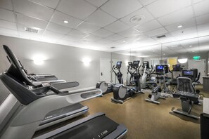 A fitness center with treadmills, elliptical machines, and stationary bikes. - Lavish Beachfront Condo | Rooftop Pool/Spa/Gym (Marco Island)