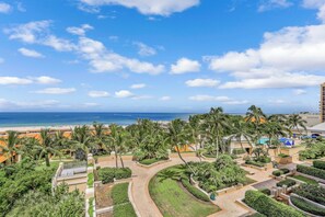 Un resort amb vistes a la platja, palmeres i una zona de piscina.