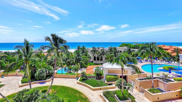 Ein Resort mit Pool, Palmen und Blick auf den Ozean.