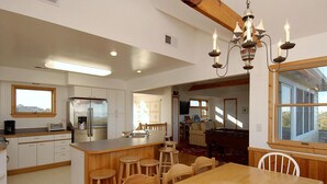 A spacious kitchen with a central island, wooden stools, and a dining table. - 2060 - DoodleBug - Corolla Retreat | Private Pool & Walk to Beach (Corolla)