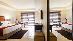 A hotel room with a bed, a desk, a chair, and a TV. - Lodge by Eagles (Sekondi-Takoradi)