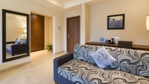 A modern living room with a sofa, a coffee table, and a dining area. - Lodge by Eagles (Sekondi-Takoradi)