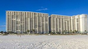 Een groot, meerhoog hotel met een gelijkmatig uiterlijk, gelegen naast een zandstrand.